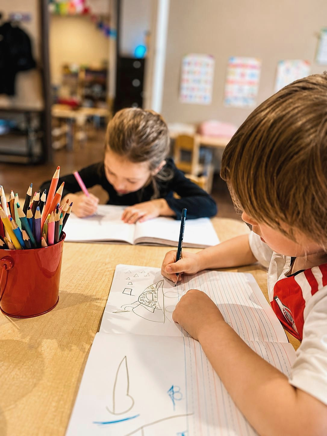 Children drawing and journaling together in a Lincoln Park classroom at L&L Academy and Preschool