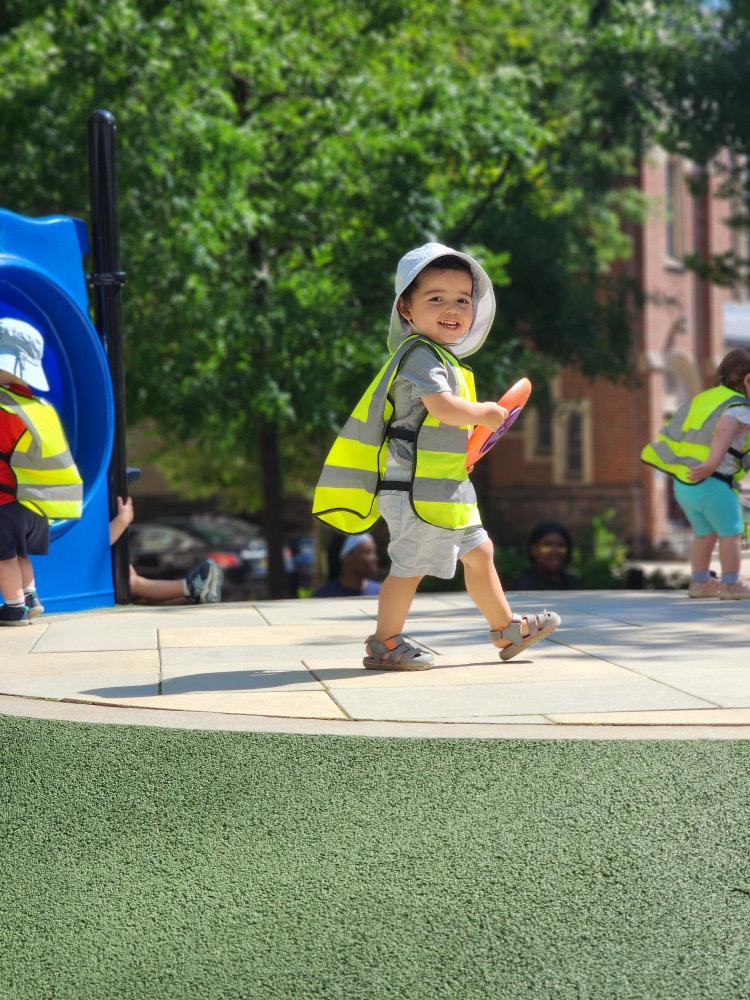 A toddler exploring outdoor play at L&L Lincoln Park.