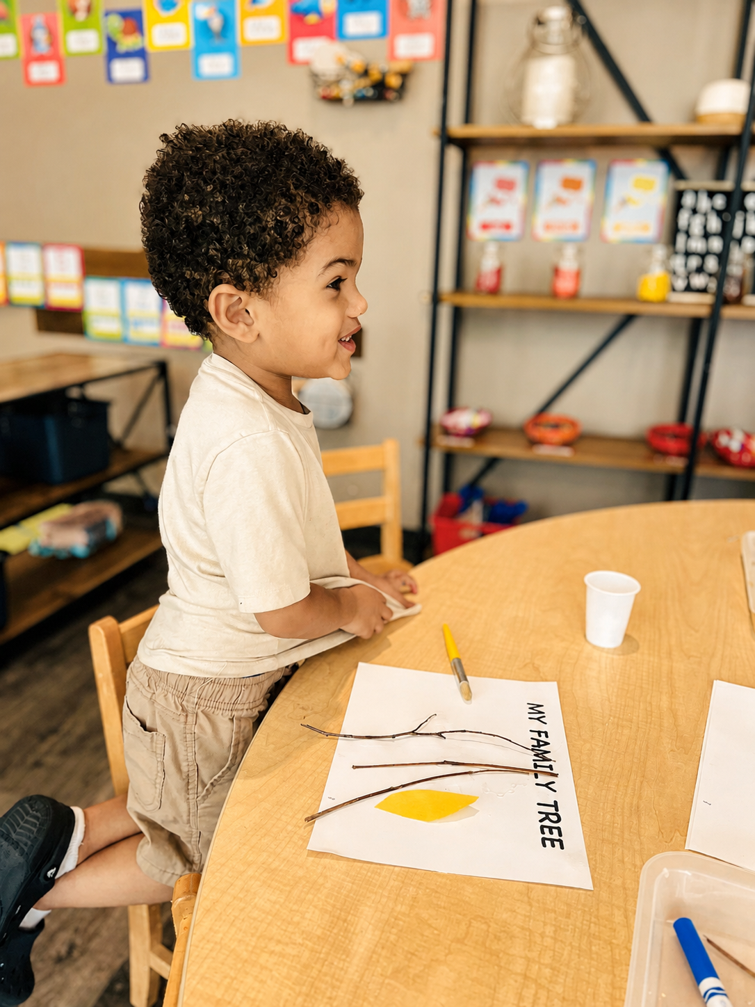 Preschool child creating a family-tree project during classroom learning time.
